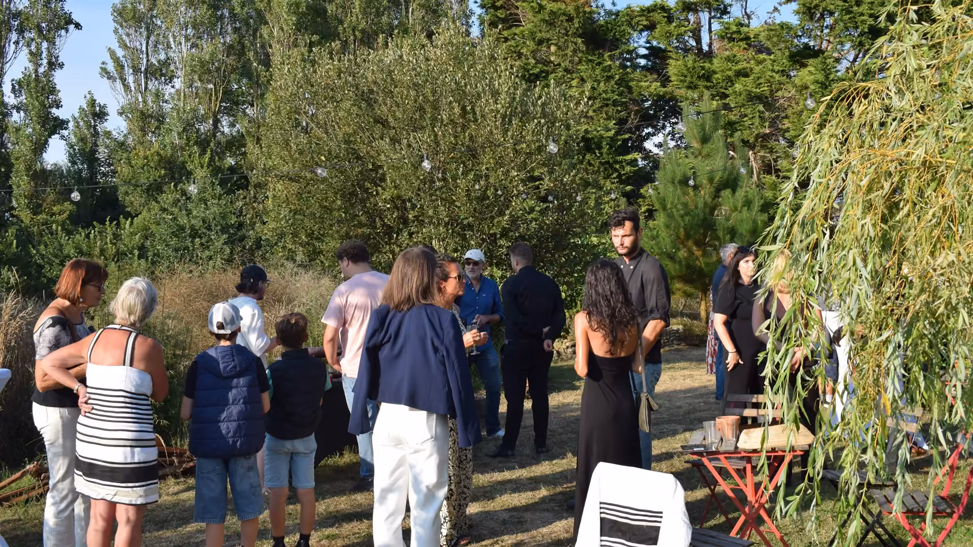 Invités réunis dans le jardin à Henvic lors d’une réception client organisée par Rivage